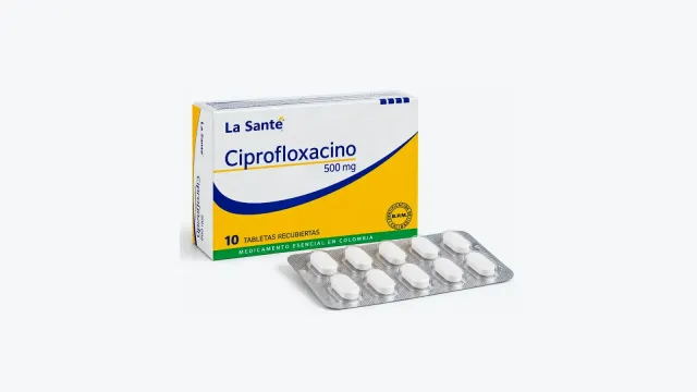 Caja de Ciprofloxacino 500 mg La Santé de 10 tabletas recubiertas junto a un blíster de tabletas blancas