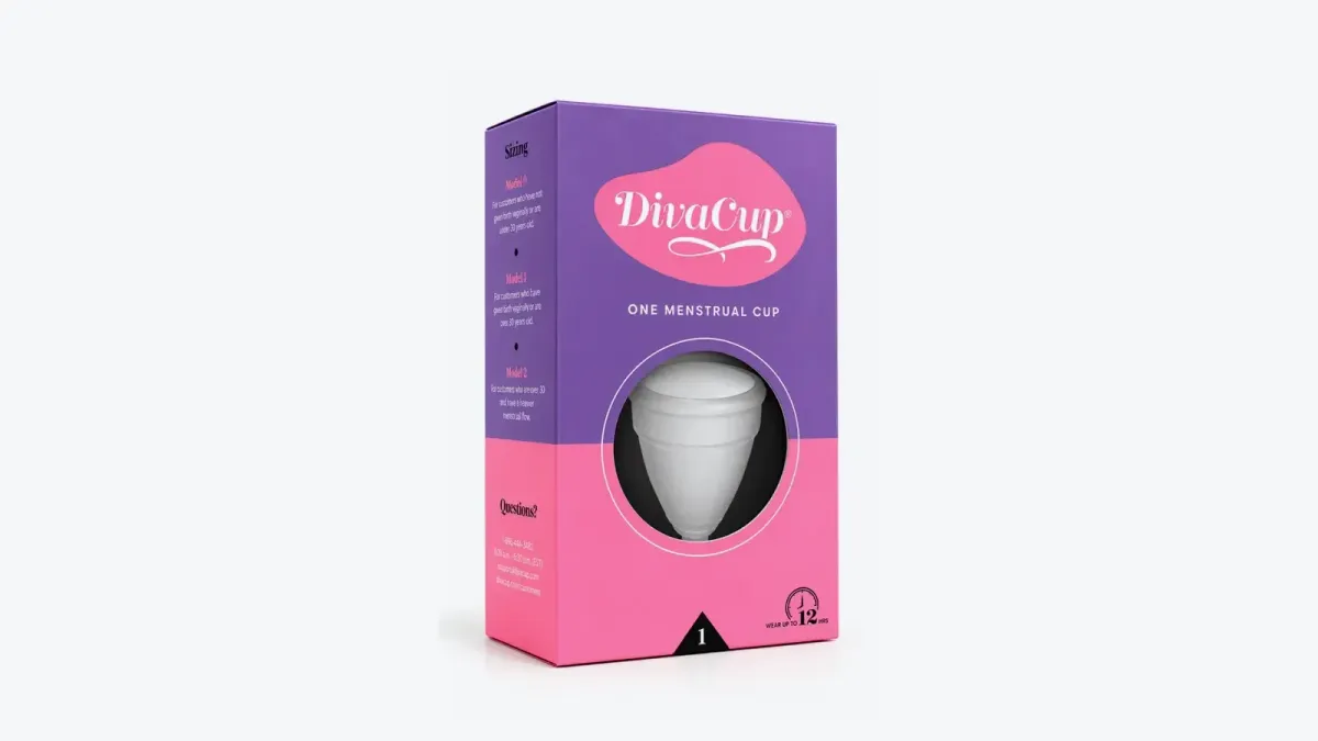 Caja morada y rosada de la copa menstrual DivaCup con la copa translúcida visible en el centro