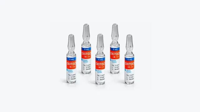 Cinco ampollas de vidrio de oxitocina de 5 mL con etiqueta roja y azul, vía intramuscular e intravenosa